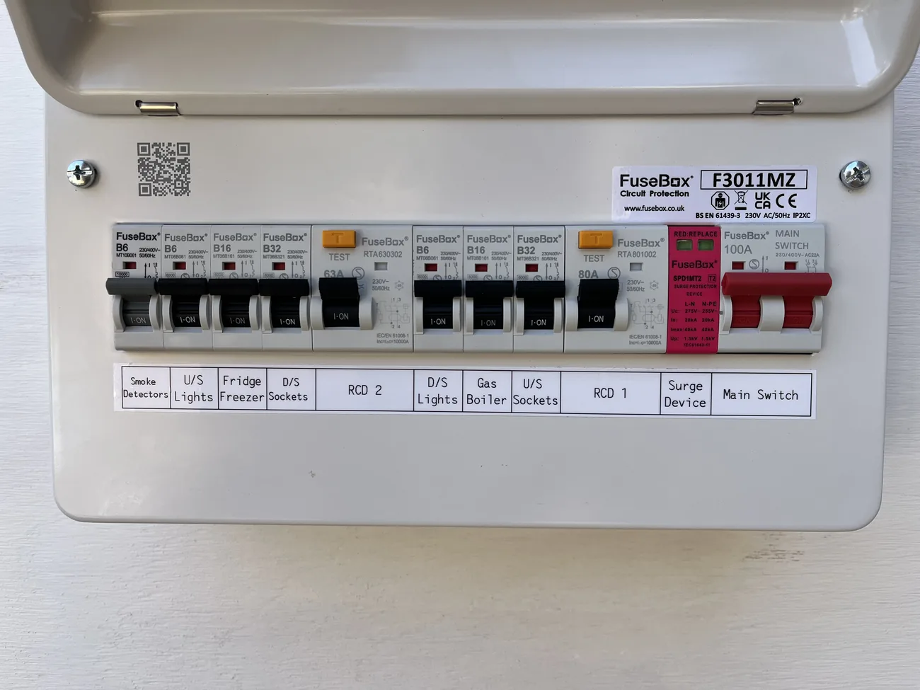 An older split-load consumer unit with two RCD switches, each protecting half the circuits