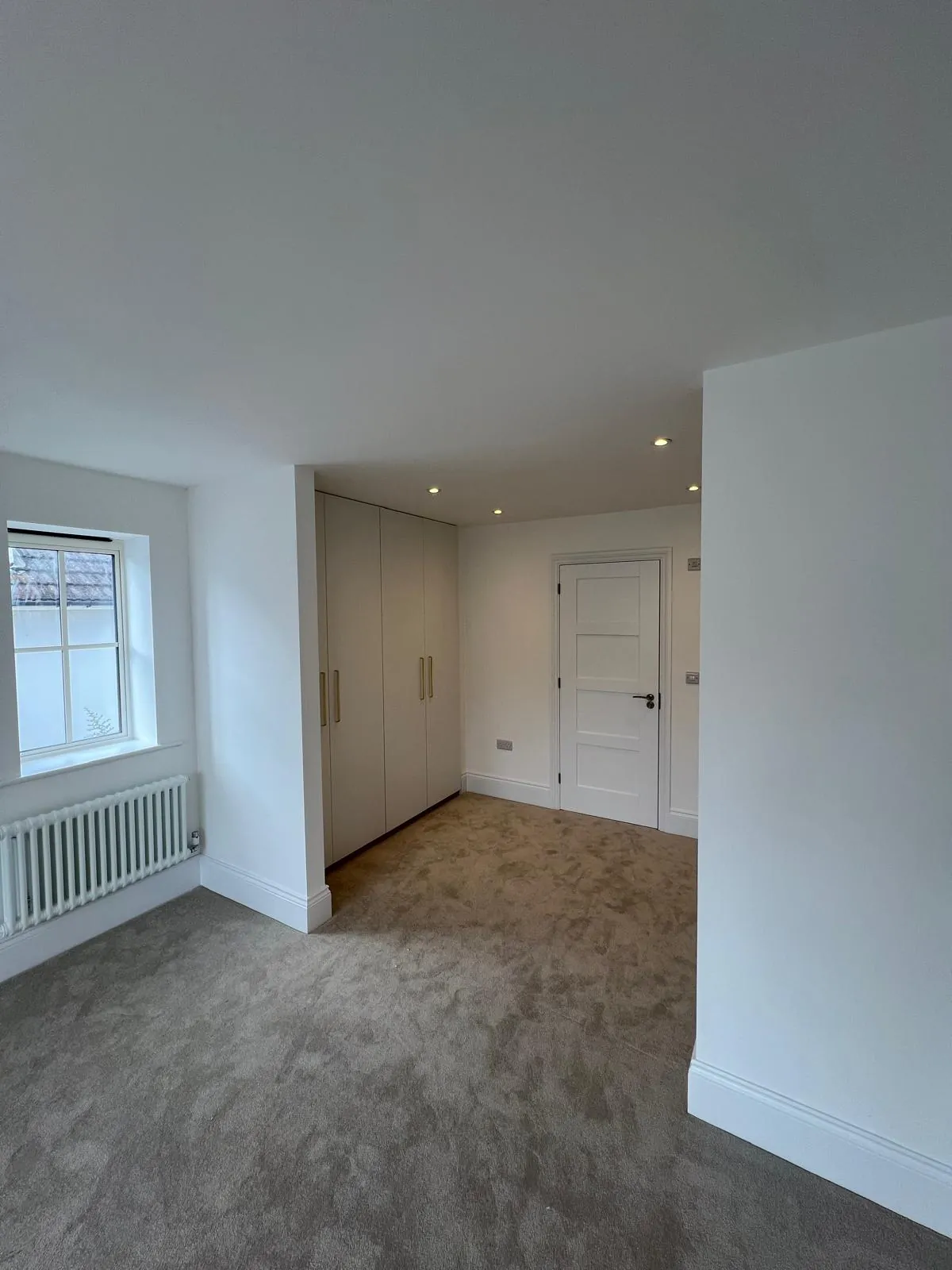 Finished self-build bedroom with recessed downlights and fitted wardrobes in Poole