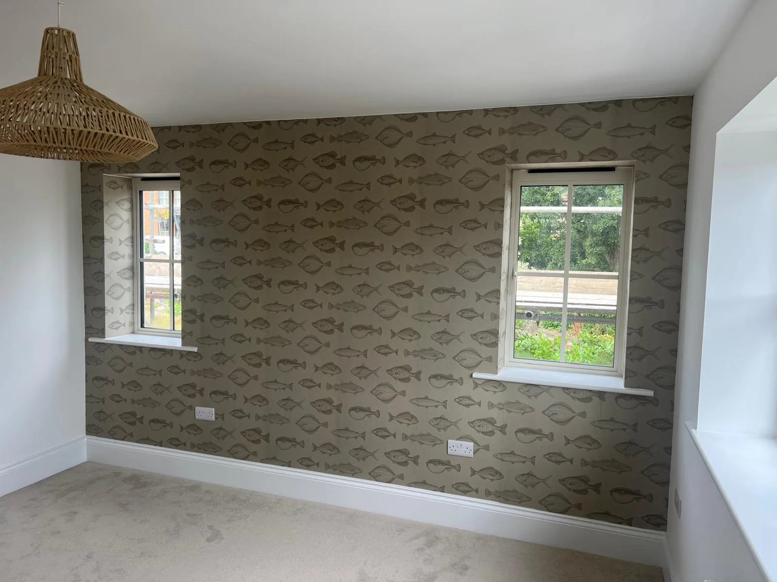 Finished self-build bedroom with a feature wall, pendant light and wall lights, wired by Dorset Rewires in Poole