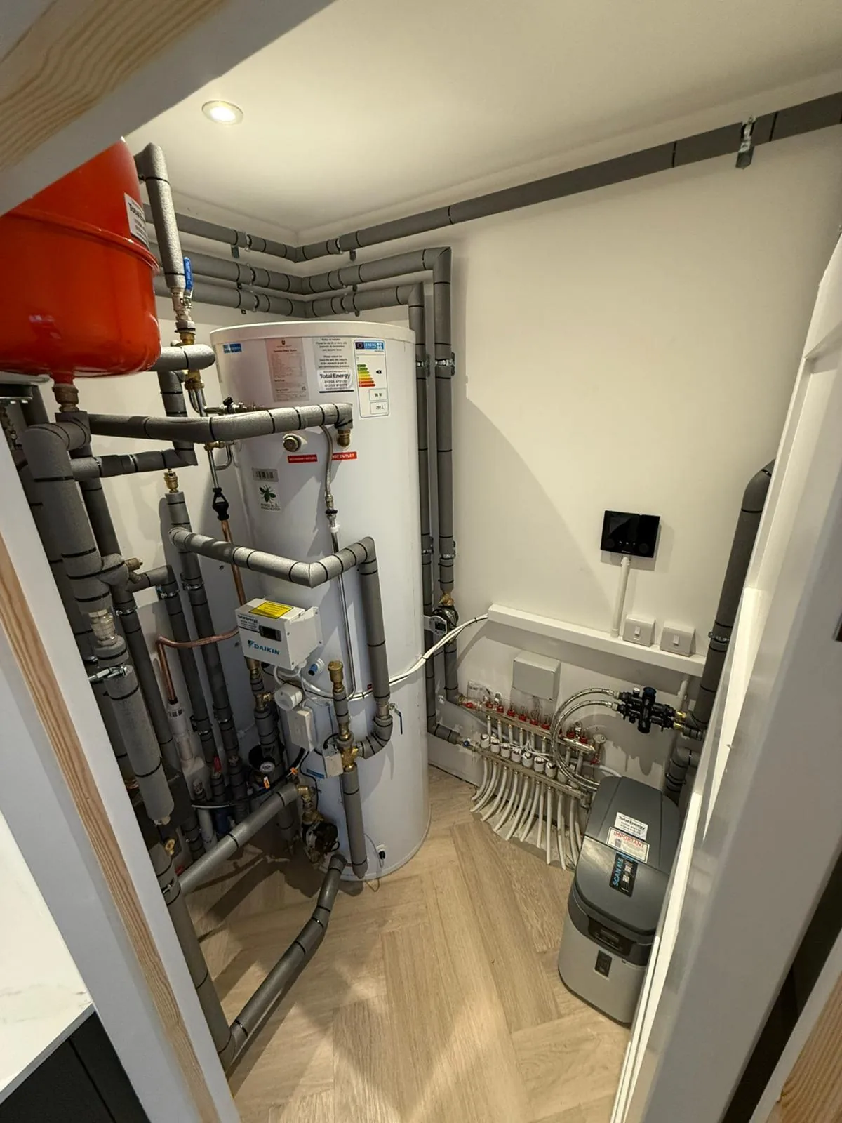 New build plant room with a hot water cylinder, heating manifold and electrical controls, wired by Dorset Rewires